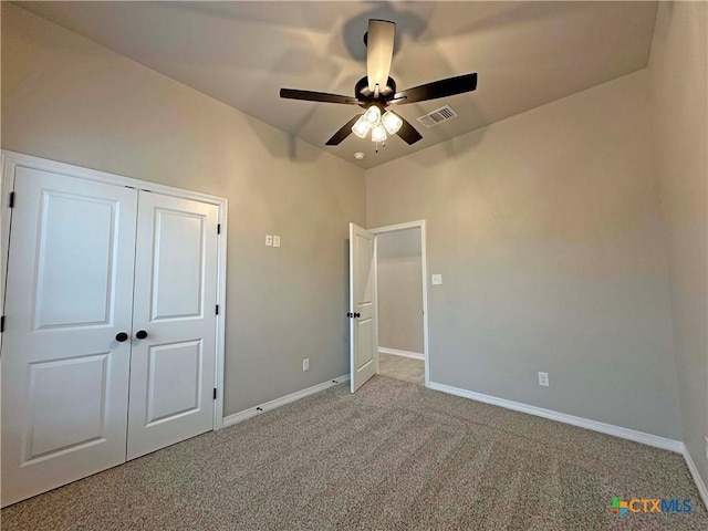 unfurnished bedroom featuring a closet, ceiling fan, and carpet flooring