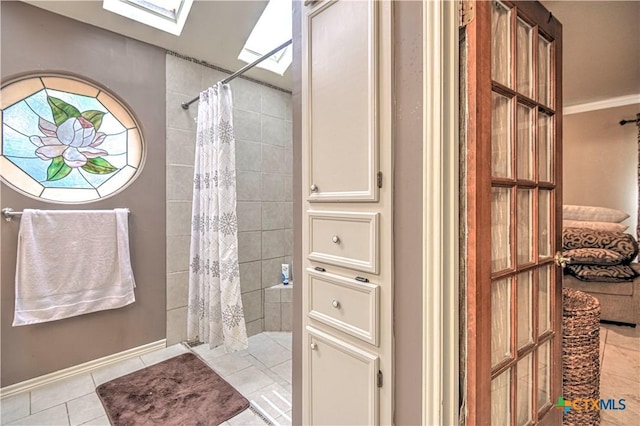3618 Bobcat Trl, Temple, TX 76502 - full bathroom featuring a skylight, a tile shower, tile patterned floors, and baseboards