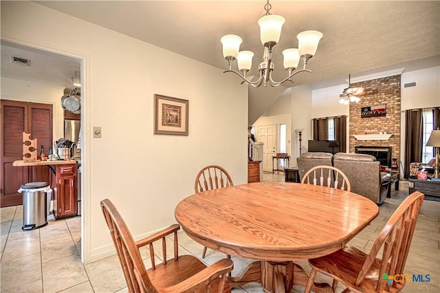 3618 Bobcat Trl, Temple, TX 76502 - dining space featuring light tile patterned flooring, a brick fireplace, a chandelier, and a ceiling fan