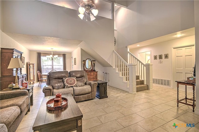 3618 Bobcat Trl, Temple, TX 76502 - living room with a high ceiling, a ceiling fan, a chandelier, stairway, and light tile patterned floors