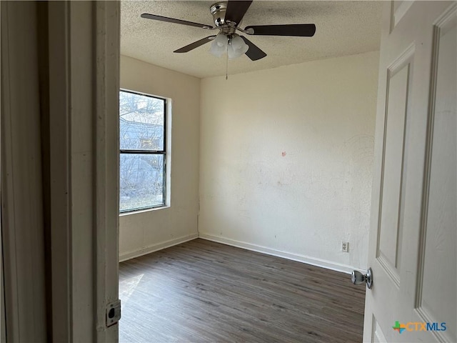 unfurnished room featuring a textured ceiling, dark hardwood / wood-style floors, and ceiling fan