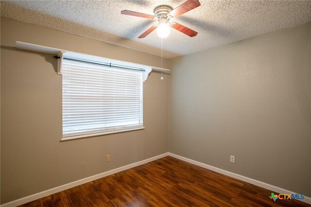 unfurnished room with a textured ceiling, a ceiling fan, baseboards, and wood finished floors