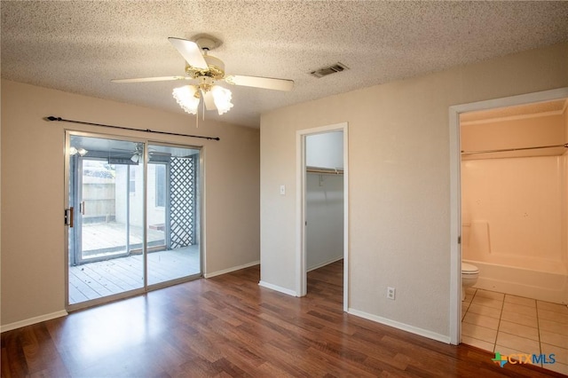 unfurnished bedroom with wood finished floors, a textured ceiling, and access to exterior