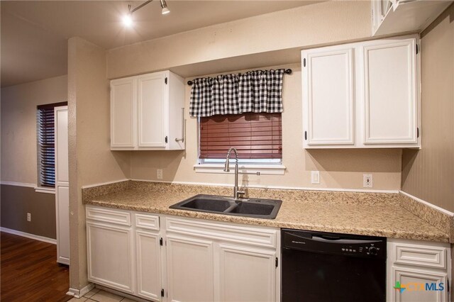 kitchen featuring wood finished floors, a sink, white cabinets, rail lighting, and black dishwasher