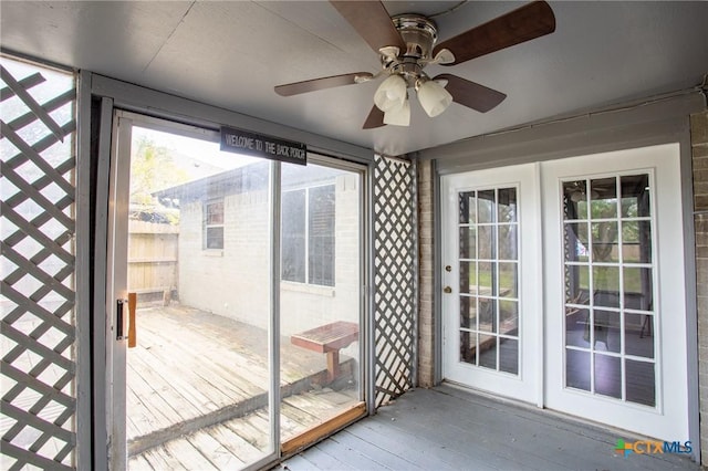 unfurnished sunroom featuring ceiling fan