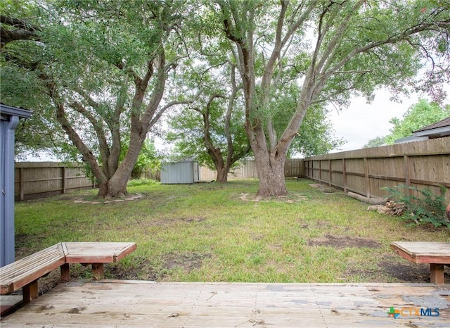 view of yard with a storage unit, an outbuilding, and a fenced backyard