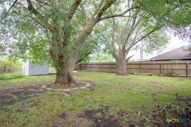 view of yard with an outdoor structure, a shed, and fence