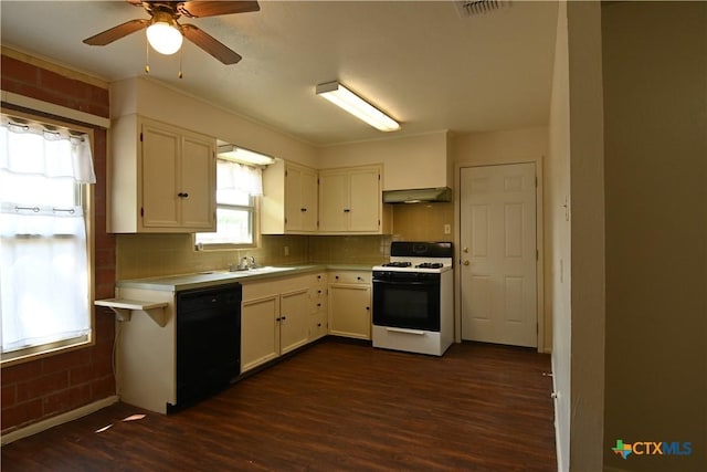 kitchen with white gas range oven, light countertops, dark wood-style floors, under cabinet range hood, and black dishwasher