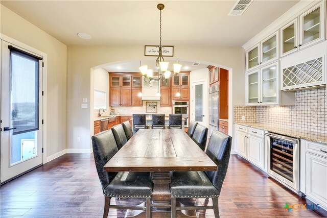 dining area featuring dark wood-type flooring, a wealth of natural light, and wine cooler