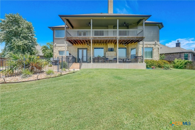 rear view of property with a patio, a yard, ceiling fan, and a balcony