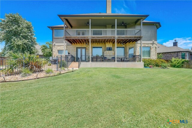 rear view of property with a patio, a yard, ceiling fan, and a balcony