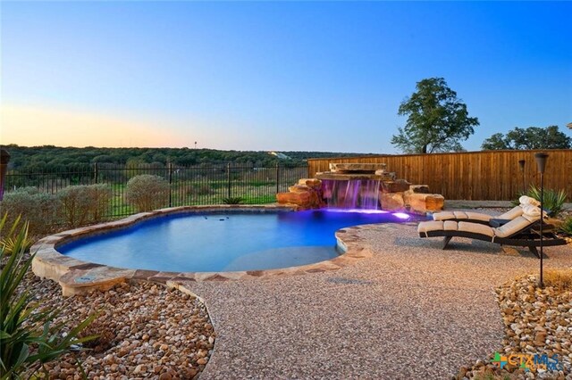 pool at dusk with pool water feature