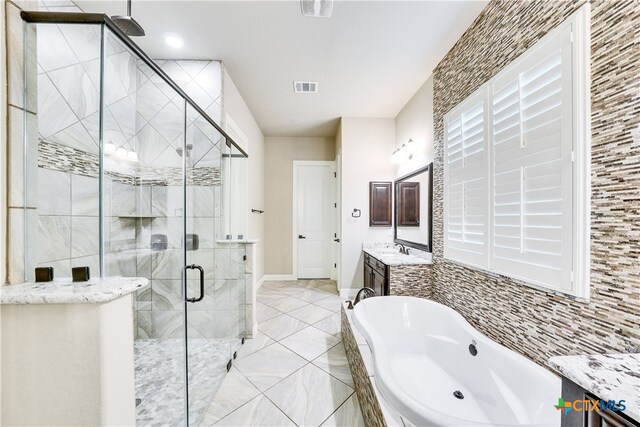 bathroom with vanity and independent shower and bath