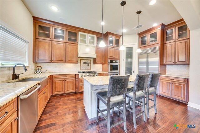 kitchen featuring dark hardwood / wood-style flooring, light stone countertops, sink, and stainless steel appliances