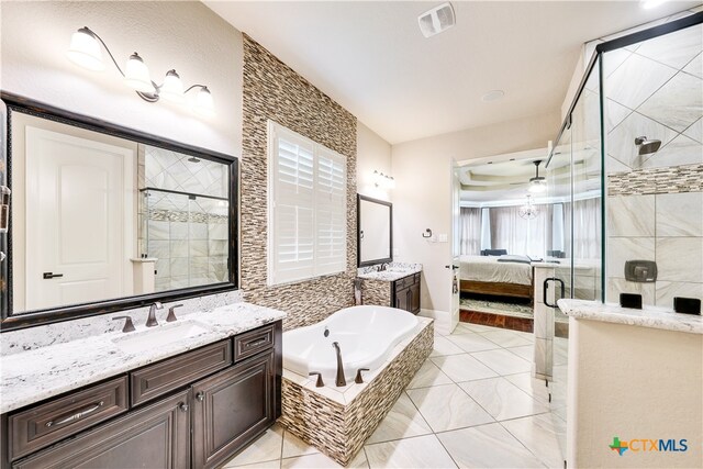 bathroom with plus walk in shower, vanity, and tile patterned floors