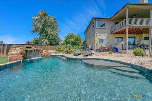 view of swimming pool with ceiling fan, a patio, and pool water feature