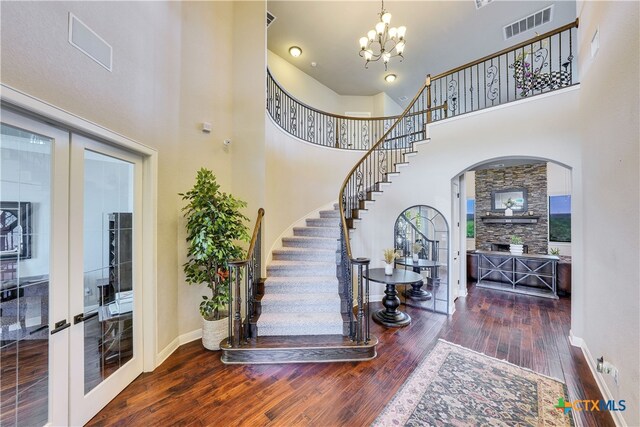 entrance foyer featuring french doors, dark hardwood / wood-style flooring, a chandelier, and a high ceiling