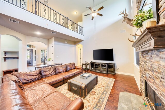 living room with hardwood / wood-style floors, ceiling fan, and high vaulted ceiling