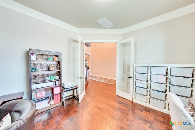 office area with wood-type flooring, crown molding, and french doors