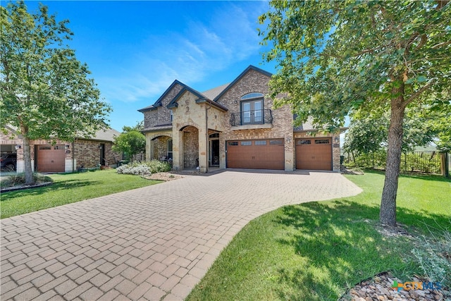 french country home featuring a garage and a front lawn