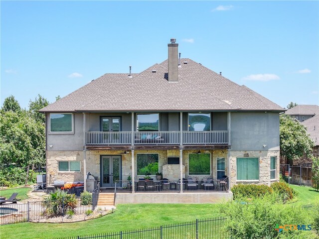 rear view of property featuring a balcony, a lawn, outdoor lounge area, and a patio area