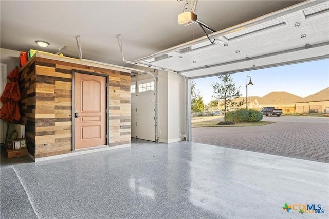 garage with a garage door opener and wood walls