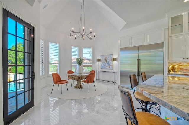 dining room featuring high vaulted ceiling and a notable chandelier