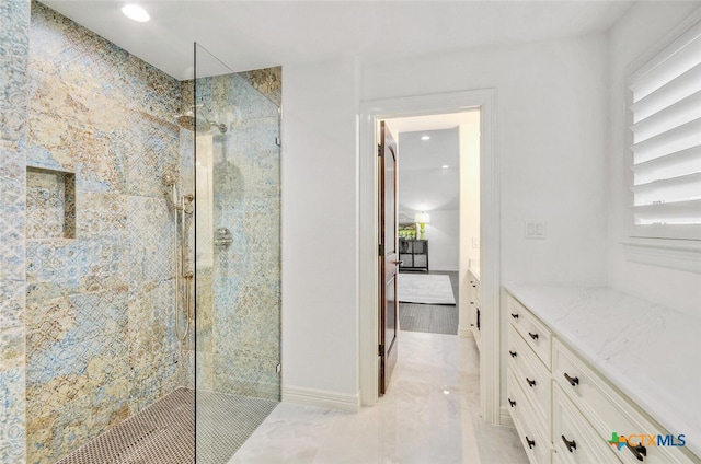 bathroom with vanity and a tile shower