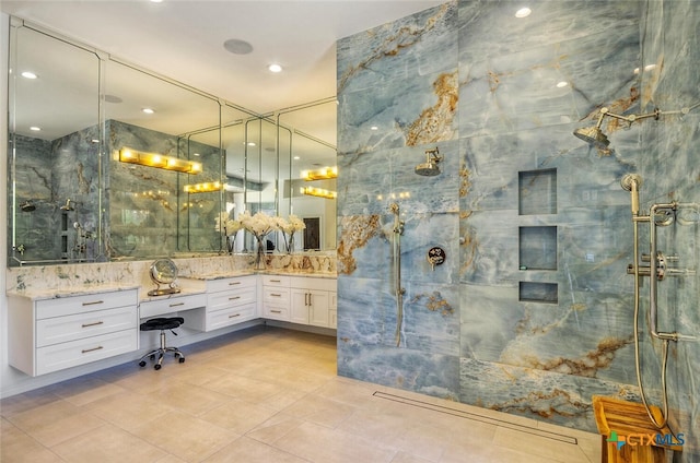 bathroom featuring vanity, tile patterned flooring, and a tile shower