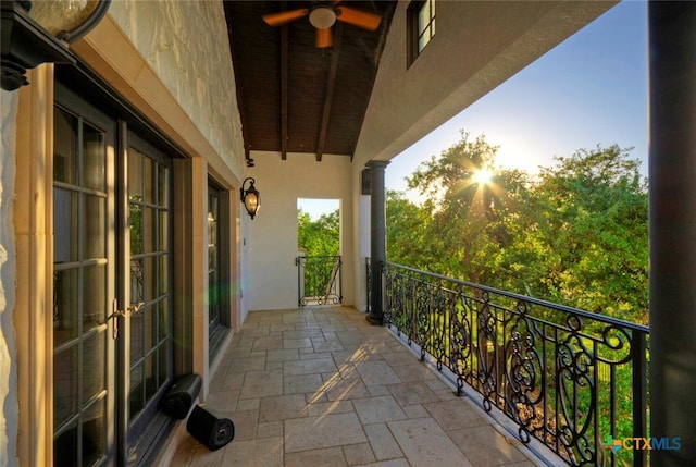 balcony at dusk featuring ceiling fan