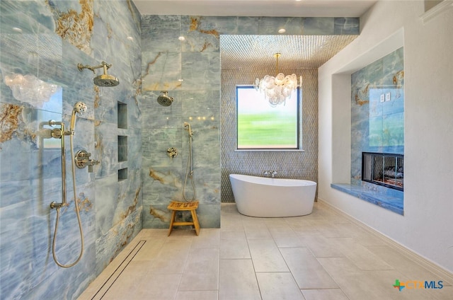 bathroom featuring shower with separate bathtub, tile patterned floors, and a notable chandelier