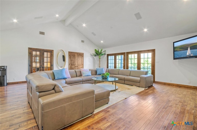 living room featuring beamed ceiling, high vaulted ceiling, light hardwood / wood-style flooring, and french doors