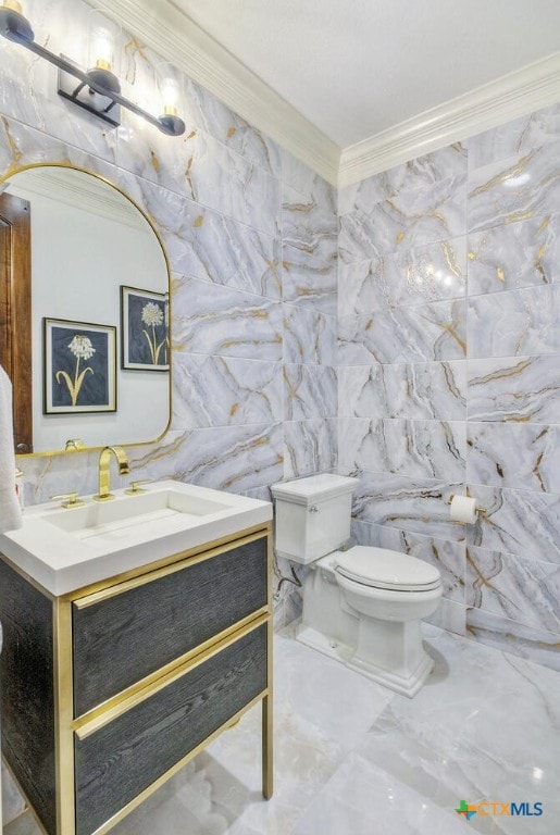 bathroom with vanity, crown molding, toilet, and tile walls