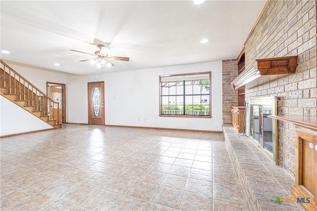 679 Royal Rd, Port Lavaca, TX 77979 - unfurnished living room featuring a fireplace, baseboards, stairs, a ceiling fan, and recessed lighting