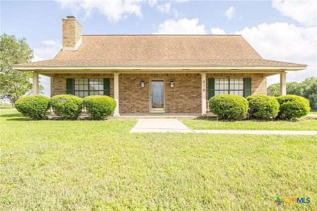 679 Royal Rd, Port Lavaca, TX 77979 - view of front of house with brick siding, a front lawn, a chimney, and a shingled roof