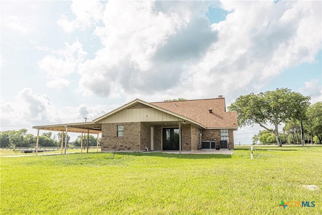 679 Royal Rd, Port Lavaca, TX 77979 - rear view of house with french doors, an attached carport, a yard, brick siding, and central AC unit