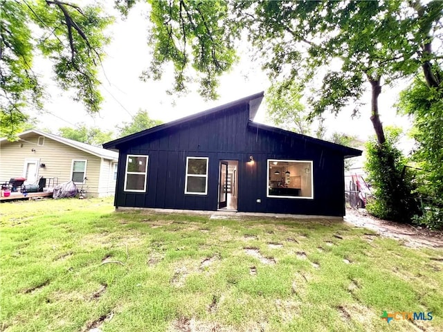 107 S 23rd St, Temple, TX 76504 - back of house featuring board and batten siding and a lawn