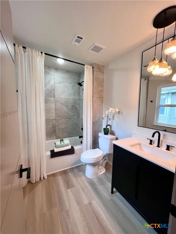 107 S 23rd St, Temple, TX 76504 - bathroom with shower / bath combo with shower curtain, toilet, vanity, and wood finished floors