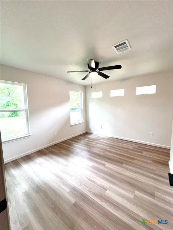 107 S 23rd St, Temple, TX 76504 - empty room featuring baseboards, light wood-style flooring, and a ceiling fan