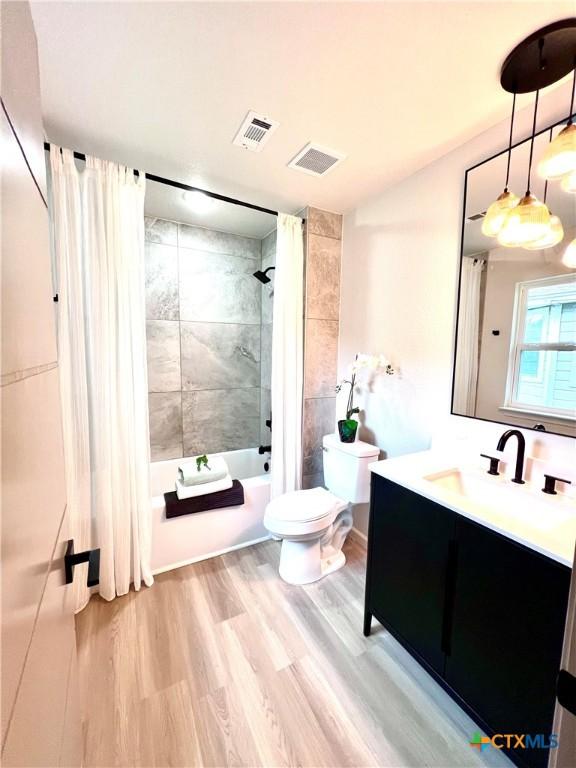 107 S 23rd St, Temple, TX 76504 - bathroom with toilet, shower / bath combo, vanity, and wood finished floors