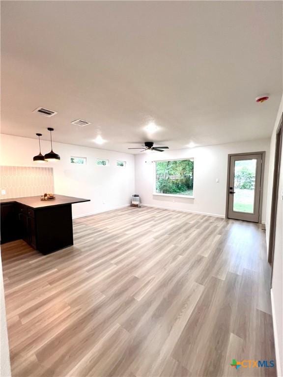 107 S 23rd St, Temple, TX 76504 - unfurnished living room with ceiling fan, light wood-style floors, and healthy amount of natural light
