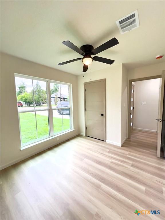 107 S 23rd St, Temple, TX 76504 - spare room featuring baseboards, light wood finished floors, and a ceiling fan