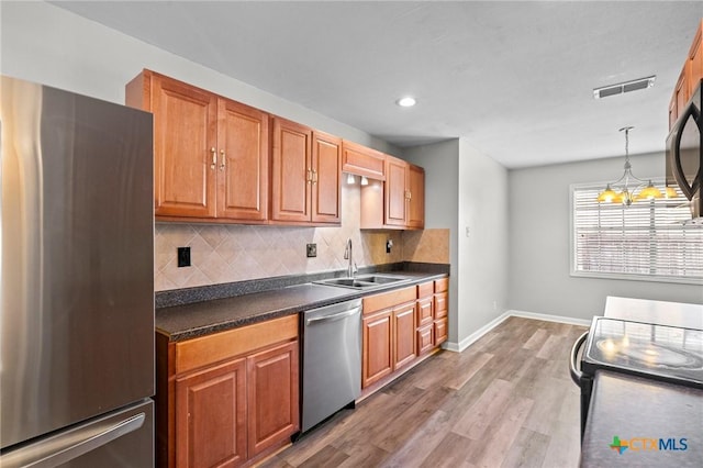 116 Guinevere St, Victoria, TX 77904 - kitchen featuring appliances with stainless steel finishes, sink, pendant lighting, and decorative backsplash