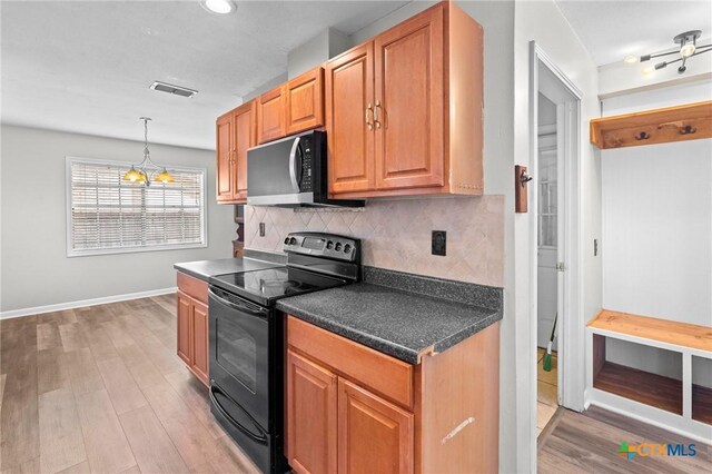 116 Guinevere St, Victoria, TX 77904 - kitchen featuring black range with electric stovetop, light hardwood / wood-style flooring, hanging light fixtures, and backsplash