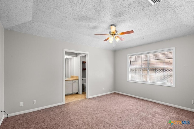 116 Guinevere St, Victoria, TX 77904 - unfurnished bedroom featuring ensuite bathroom, a textured ceiling, and light colored carpet