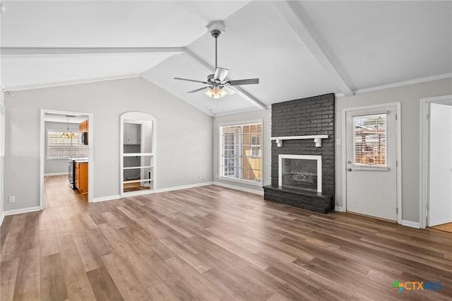 116 Guinevere St, Victoria, TX 77904 - unfurnished living room featuring ceiling fan, wood-type flooring, lofted ceiling with beams, and a brick fireplace