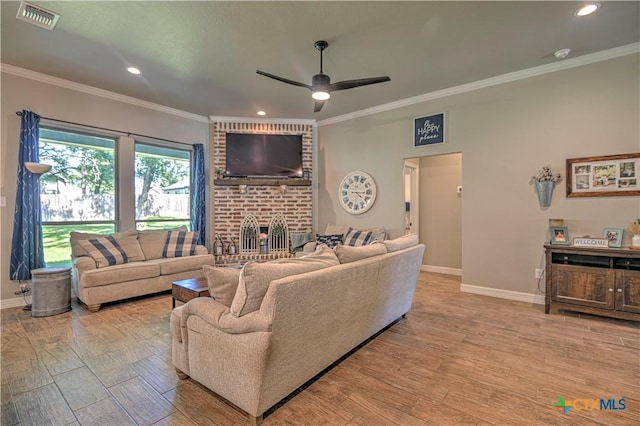 6129 Messina Dr, Temple, TX 76502 - living area with wood finished floors, ornamental molding, a brick fireplace, ceiling fan, and recessed lighting