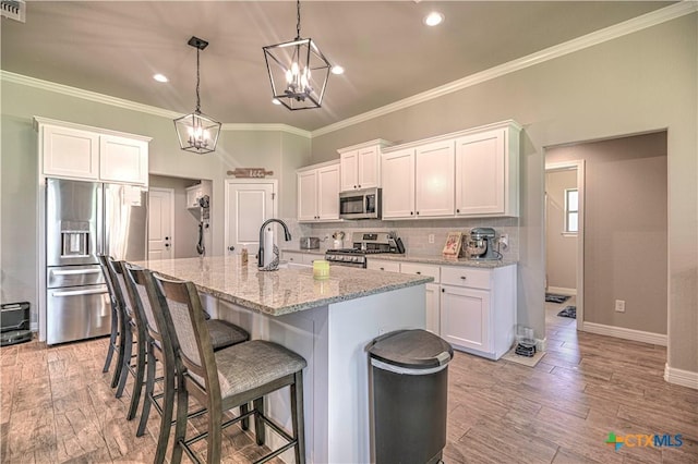 6129 Messina Dr, Temple, TX 76502 - kitchen featuring stainless steel appliances, a chandelier, white cabinets, decorative backsplash, and recessed lighting