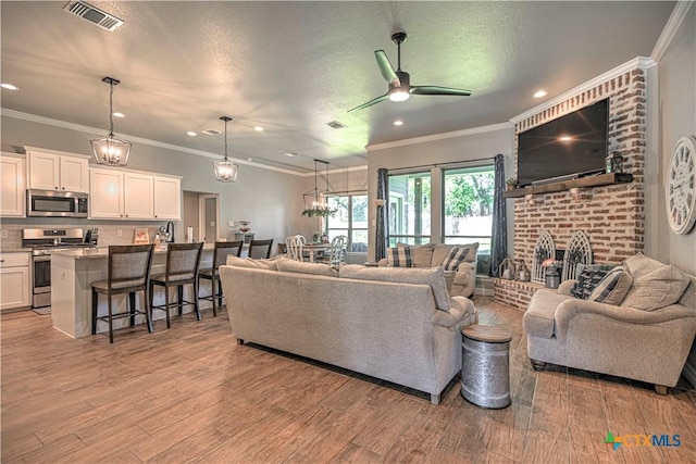 6129 Messina Dr, Temple, TX 76502 - living area with light wood-style flooring, ceiling fan, recessed lighting, a fireplace, and ornamental molding