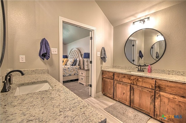6129 Messina Dr, Temple, TX 76502 - ensuite bathroom featuring lofted ceiling, a textured wall, and two vanities